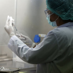 A researcher wearing a face mask and gloves as a preventive measure inside a laboratory. Chaiwat Subprasom/SOPA Images/LightRocket via Getty Images